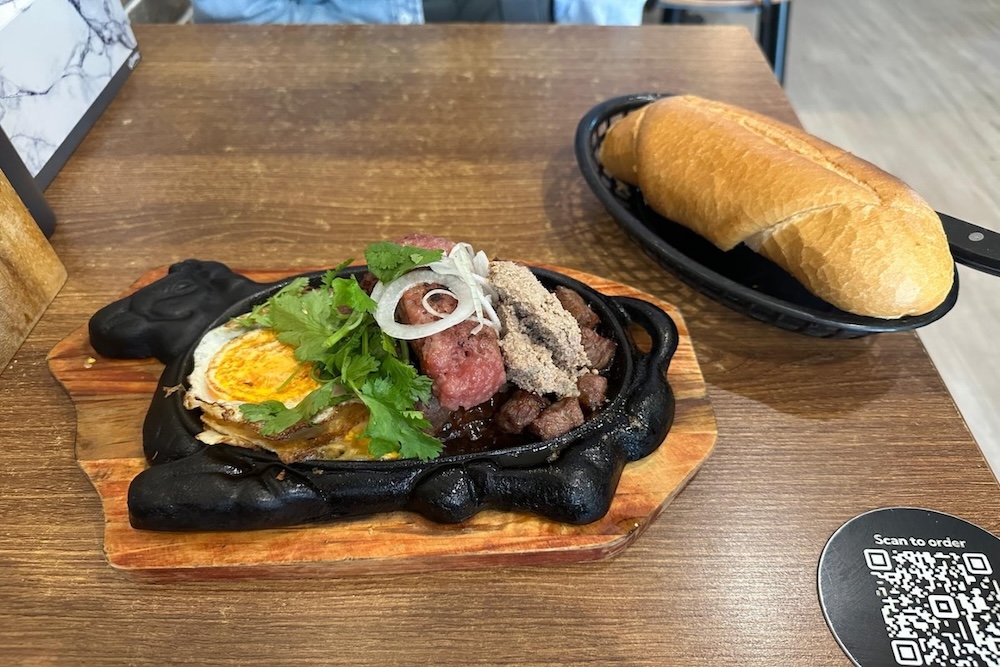 Sizzling plate beef Bo Ne at Cisne with fully cooked egg and minimal sauce