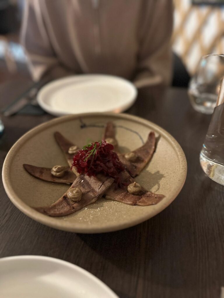 Close-up of Ox Tongue dish at Naadam Canberra with pickled red cabbage and subtle sauce