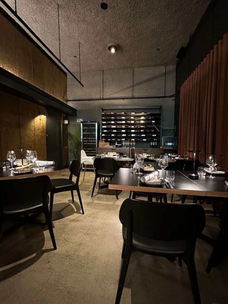 Wall-mounted wooden wine cellar display at The Q Dining restaurant in Canberra