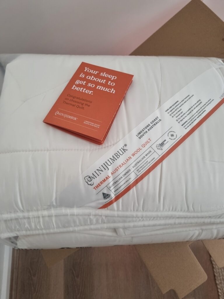 Newly opened Minijumbuk wool quilt neatly folded inside the packaging box