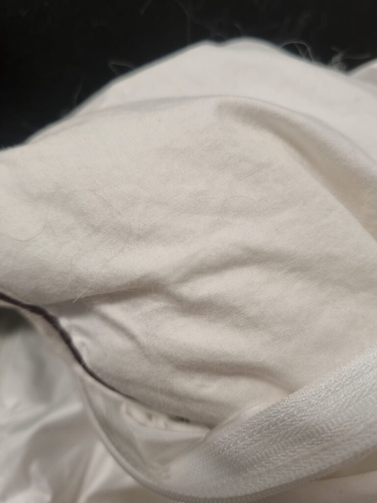 Close up of shedding wool fibers leaking from an old wool quilt