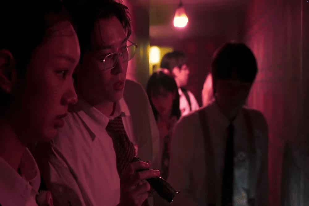 The investigation team looking shocked and surprised under intense red lighting